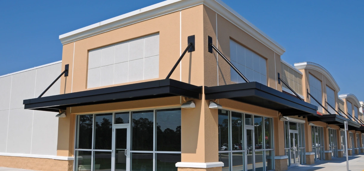 A building with a large window and a black awning.